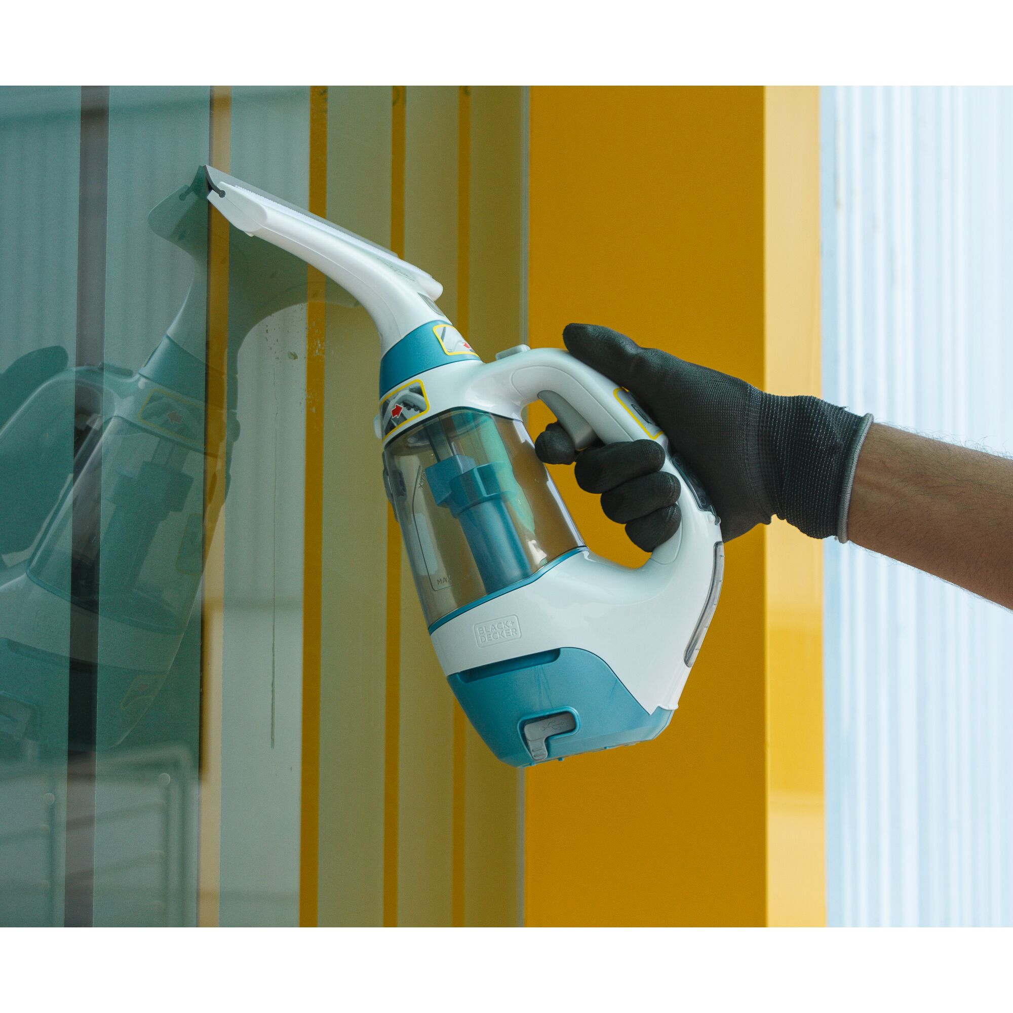 BLACKDECKER WW100 handheld window vacuum cleaner used on glass surface, side angle, blue and white body