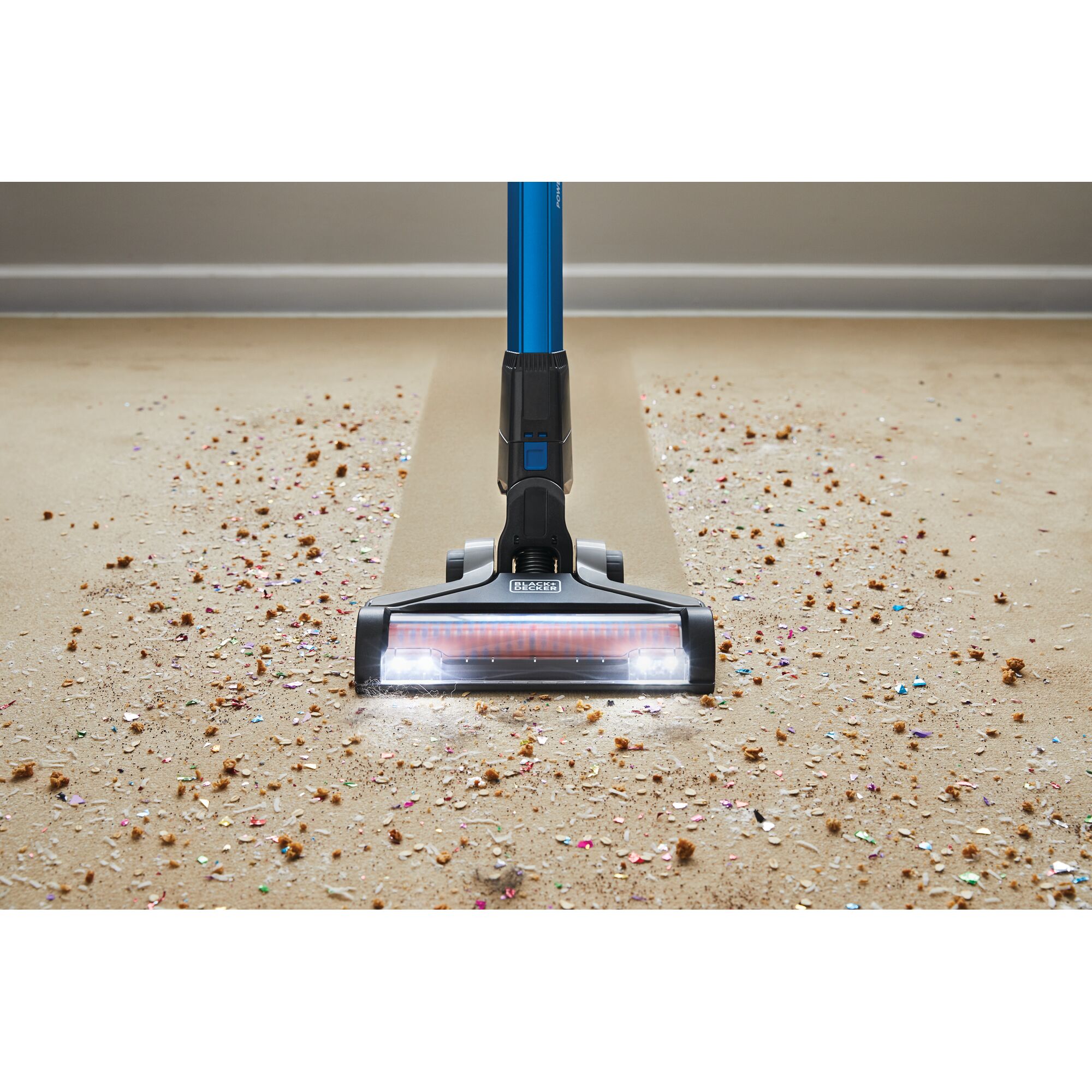 BLACKDECKER BSV2020G stick vacuum with LED lights cleaning debris on carpet, front angle.